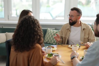 İş arkadaşları öğle arasında ofiste sohbet ediyorlar.