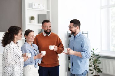 Ofiste kahve molası sırasında iş arkadaşları sohbet ediyor.
