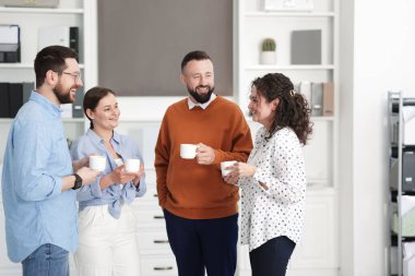 Ofiste kahve molası sırasında iş arkadaşları sohbet ediyor.