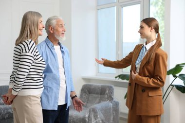 Gülümseyen emlakçı içeride çiftlere daire gösteriyor.