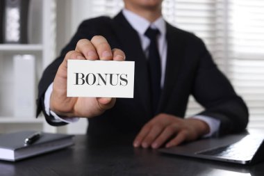 İş adamı masada kelime ikramiyesi ile kart gösteriyor, yakın plan.