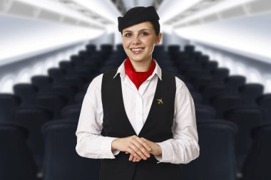 Kabinde rahat koltukları olan gülümseyen hostes.