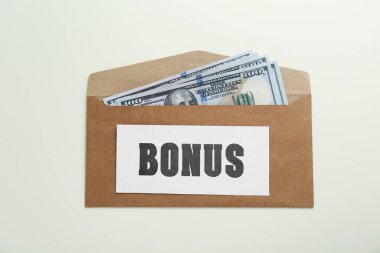 İkramiye. Beyaz arka planda dolar banknotları olan zarf, üst görünüm