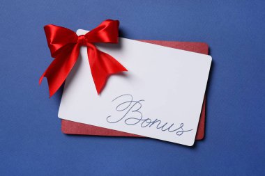 Mavi arka planda kırmızı fiyonklu bonus kart, üst görünümde