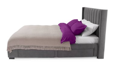 Beyaz arka planda güzel çarşaflarla yapılmış bir yatak.