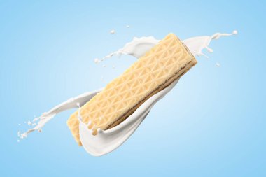 Lezzetli çıtır gofret ve açık mavi arka planda sütü sıçratma