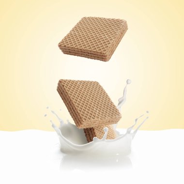 Lezzetli gevrek gofretler bej arka plana süt sıçratıyor.