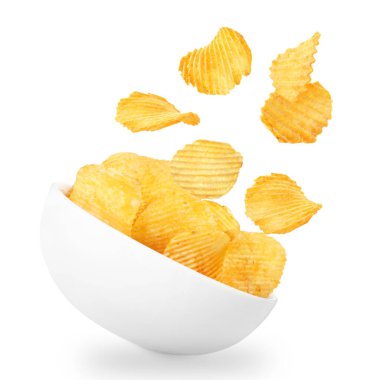 Lezzetli patates cipsleri beyaz arka planda kaseye düşüyor.