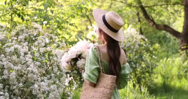 Parkta şakayık demeti olan güzel bir kadın.