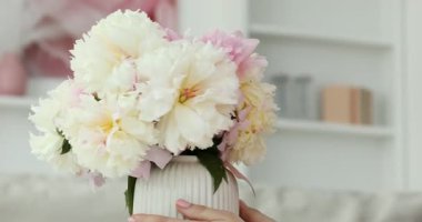 Evinde şakayık demeti olan bir kadın, yakın plan.