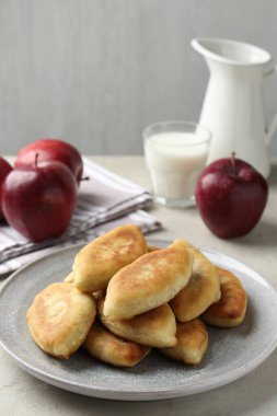 Lezzetli kızarmış pirinçler (doldurulmuş turtalar), açık gri masada elma ve süt, yakın plan