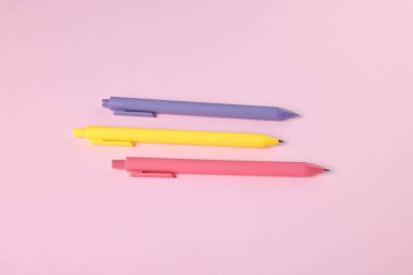 Pembe arka planda tükenmez kalemler, düz yatış