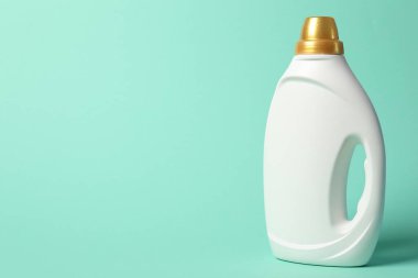 Turkuaz arka planda yumuşatıcı şişesi, metin için boşluk