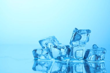 Açık mavi zemin üzerinde açık buz küpleri, yakın plan. Metin için boşluk
