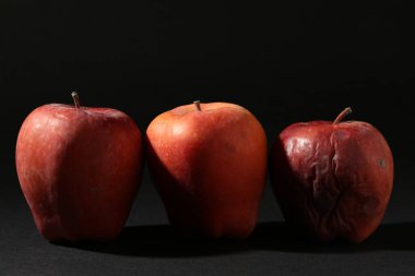 Siyah arkaplanda hasarlı kırmızı elmalar, yakın plan