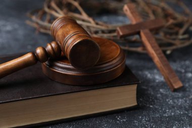 Dikenli taç, yargıç tokmağı, İncil ve ahşap haç, koyu dokulu arka plan, yakın çekim.