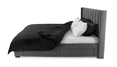 Beyaz arka planda güzel çarşaflarla yapılmış bir yatak.