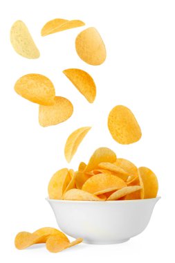Lezzetli patates cipsleri beyaz arka planda kaseye düşüyor.