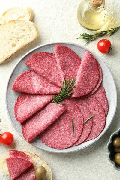 Beyaz desenli masada servis edilen biberiyeli leziz sosis dilimleri.