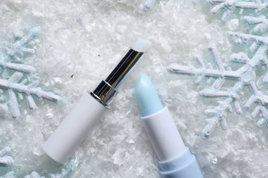 Nemlendirici dudak kremi ve yapay karla süslenmiş Noel süsü. Kış bakımı