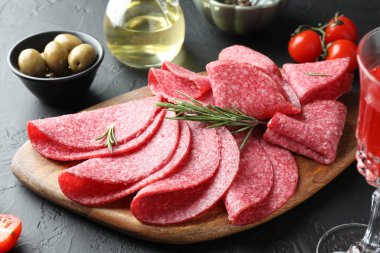 Siyah masada servis edilen biberiyeli lezzetli sosis dilimleri, yakın plan.