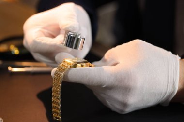 Sofrada lüks kol saati değerlendirmesi yapan Loupe eksperi, yakın plan.