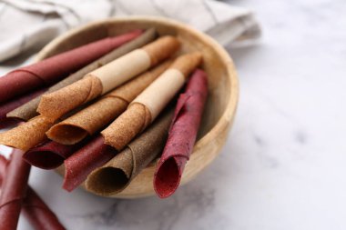 Lezzetli meyveler beyaz mermer masada yuvarlanıyor, yakın plan.