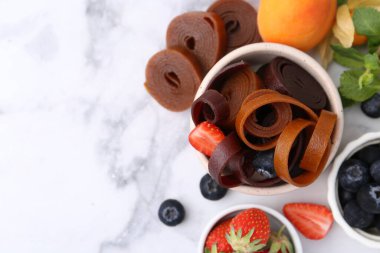 Lezzetli meyveler kasede yuvarlanıyor, nane ve böğürtlenler beyaz mermer masada, düz yerde. Metin için boşluk