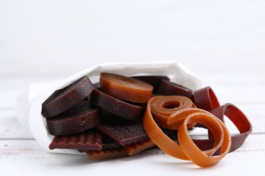 Lezzetli meyve derisi kağıt torba içinde beyaz ahşap masa üzerinde, yakın plan