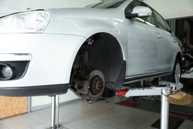 Araba servisinde lastik değiştirirken otomobili kaldırmış.