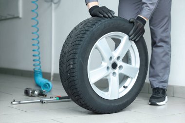 Tamirci araba servisinde lastik değiştiriyor, yakın plan.