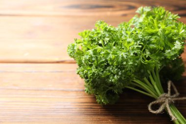 Ahşap masada bir demet taze maydanoz, yakın plan. Metin için boşluk