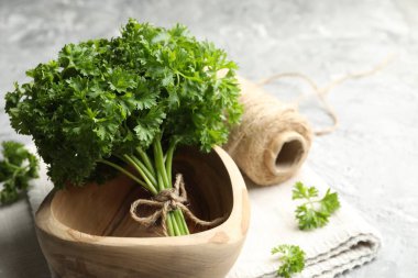 Gri desenli masada taze maydanoz ve iplik, yakın plan. Metin için boşluk