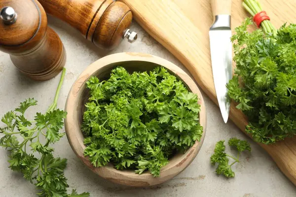 Taze maydanoz, baharat ve bıçak ışık masasında.