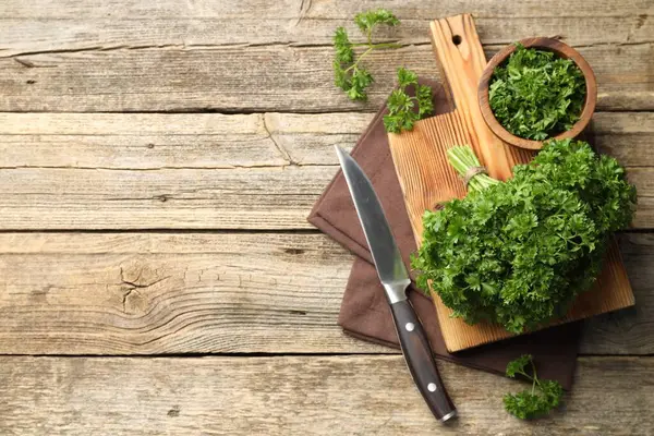 Taze maydanoz ve bıçak tahta masada, düz yerde. Metin için boşluk