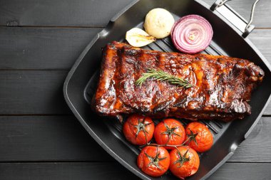 Biberiyeli domuz pirzolası, domates ve soğan. Gri ahşap masa, üst manzara.