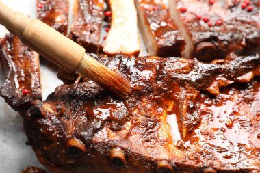 Lezzetli pirzolaların üzerine fırçayla sos serpiştiriyorum.