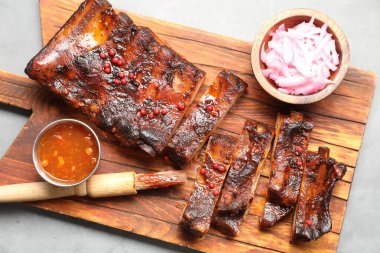 Lezzetli kaburgalar, sos, soğan ve fırça gri masada, üst manzara