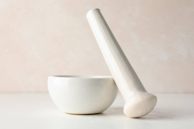 Beyaz masaya seramik havan ve tokmak, yakın plan.