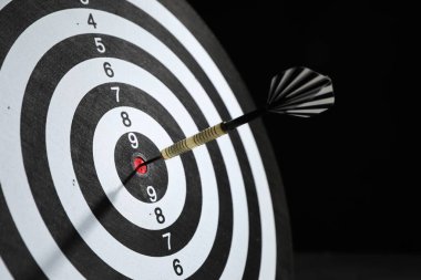 Hedef alınıyor. Karanlık arkaplanda ok olan dart tahtası, yakın plan