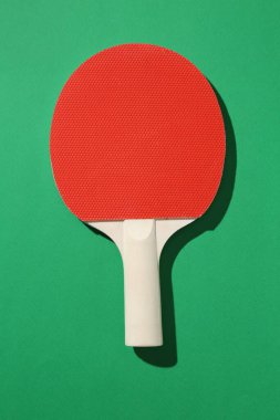 Yeşil arka planda bir ping pong raketi, üst görünüm.