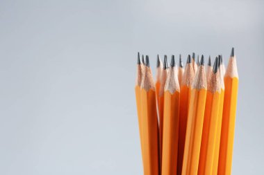 Gri arka planda keskin grafit kalemler, yakın plan. Metin için boşluk