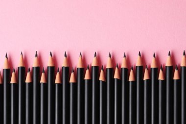 Pembe arka planda bir sürü keskin grafit kalem var. Metin için boşluk