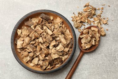 Kuru hindiba kökleri kasede ve kaşıkla gri desenli masada, düz yatıyordu.