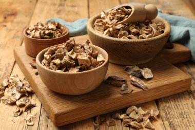 Kase içinde kuru hindiba kökleri ve ahşap masada kepçeler.