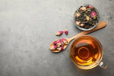 Aromatik bitki çayı, kuru yapraklar ve gri masadaki çiçekler, düz yatak. Metin için boşluk