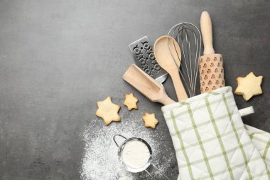 Farklı mutfak aletleri fırın eldiveninde, un ve kurabiyeler gri masada, düz yerde. Metin için boşluk