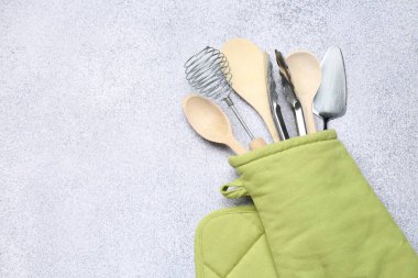 Farklı mutfak aletleri fırın eldivenlerinde, ışık masasında, üst tarafta. Metin için boşluk