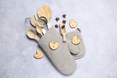 Farklı mutfak aletleri fırın eldiveni, kurabiye ve anason yıldızları ışık masasında, düz yatıyordu.