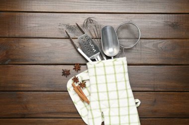 Farklı mutfak aletleri fırın eldiveni, tarçın ve anason yıldızları ahşap masa, düz yatıyordu.